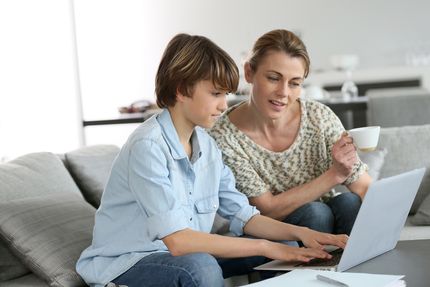 A mother helping her kid do the homework to improve their academic performance