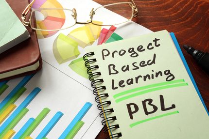 A student's notebook with Project Based Learning written on its cover